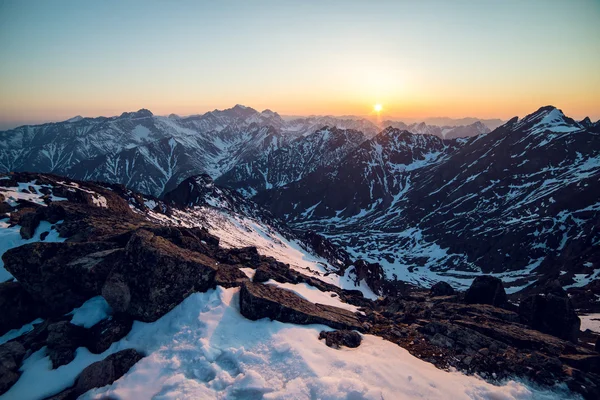 Farbenfroher bewölkter Sonnenaufgang in den schneebedeckten Bergen — Stockfoto