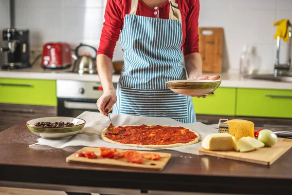 Una Cocinera Delantal Está Poniendo Salsa Tomate Una Pizza Cruda — Foto de Stock