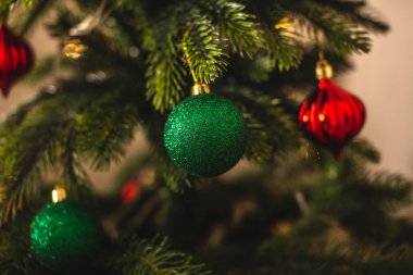 Dallarında yeşil oyuncaklar olan güzel bir Noel ağacı. Yeni yıl atmosferi ve şenlik havası kavramı.