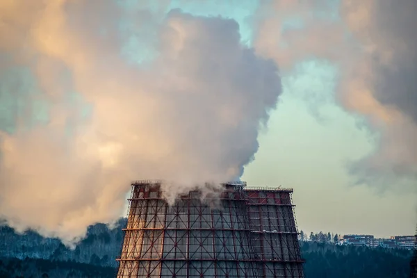 A large column of smoke is smoking from the powerful pipe of an industrial enterprise. Concept of atmospheric carbon dioxide pollution