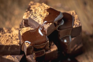 Kare şeklindeki lezzetli, iştah açıcı siyah çikolatalar bir kuleye yığılır ve sıvı çikolatayla doldurulur..