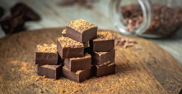 Ízletes Kocka Keserű Étcsokoládéból Kakaópor Szórva Egy Asztalon — Stock Fotó
