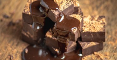 Kare şeklindeki lezzetli, iştah açıcı siyah çikolatalar bir kuleye yığılır ve sıvı çikolatayla doldurulur..