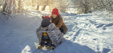 Güneşli bir günde, dondurucu bir kış sabahı çocuklu bir anne yürür. Battaniyeye sarılı bebek kızağa biniyor.