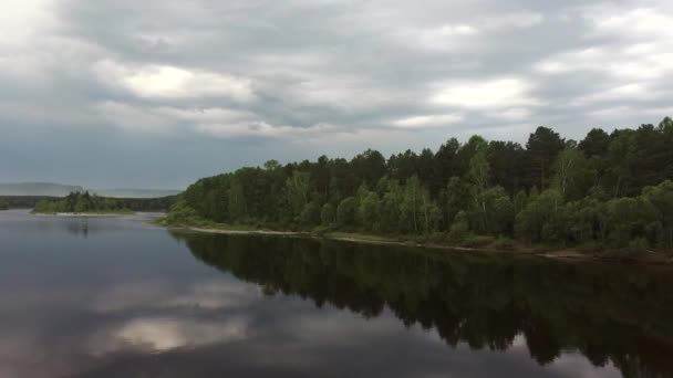 Uitzicht op de rivier tussen groene bomen bij bewolkt weer. Prachtige wilde dieren van Siberië van de drone — Stockvideo