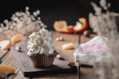 Ev yapımı iştah açıcı taze kek, kırsal bir ahşap masada krem şantili..