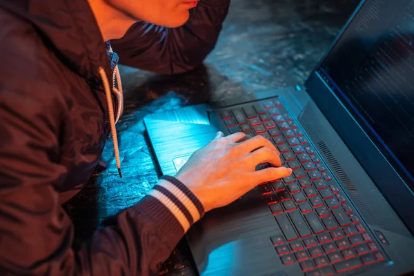 Ein Vermummter Hacker Tippt Einem Dunklen Raum Unter Neonlicht Auf — Stockfoto