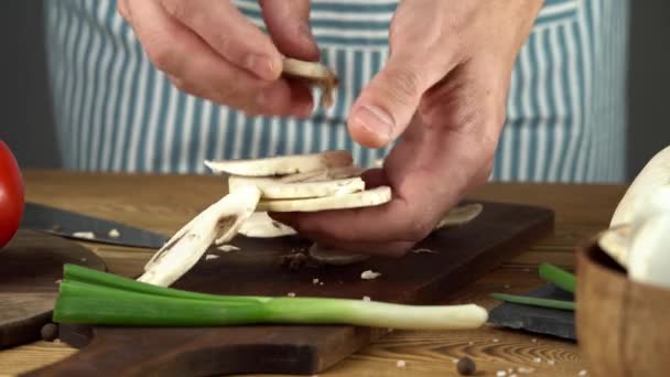 Şef taze doğranmış mantarları kaseye koyuyor. Yemek pişirme süreci kavramı — Stok video