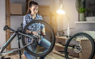 Atölyedeki bir kadın bisikletini söküyor ve tamir ediyor. Yeni sezon için bakım ve hazırlık kavramı