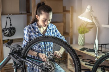 Atölyedeki bir kadın bisikletini söküyor ve tamir ediyor. Yeni sezon için bakım ve hazırlık kavramı