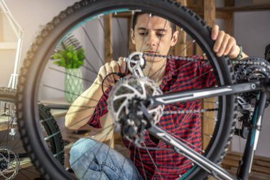 Atölyedeki bir adam bisikletini söküyor ve tamir ediyor. Yeni sezon için bakım ve hazırlık kavramı