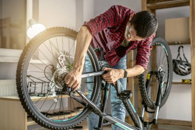 Atölyedeki bir adam bisikletini söküyor ve tamir ediyor. Yeni sezon için bakım ve hazırlık kavramı