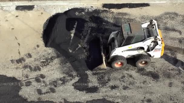 Les travailleurs déposent un nouveau revêtement d'asphalte à l'aide de bitume chaud. Travaux de machinerie lourde et de pavage. Vue du dessus — Video