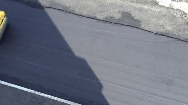 I lavoratori pongono un nuovo rivestimento di asfalto utilizzando bitume caldo. Lavoro di macchinari pesanti e spianatrice. Vista dall'alto — Video Stock