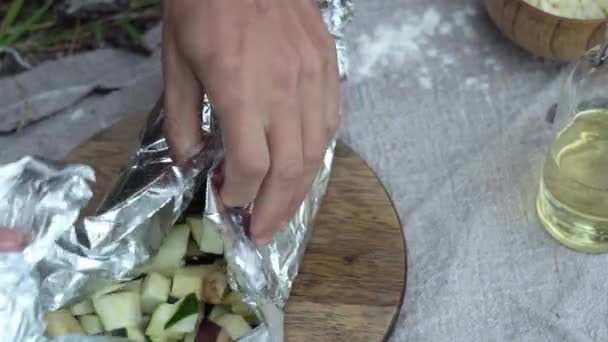 İnsanoğlu ateşin üzerinde pişirebilmek için sebzeleri folyoyla sarıyordu. Doğada yemek pişirme kavramı — Stok video