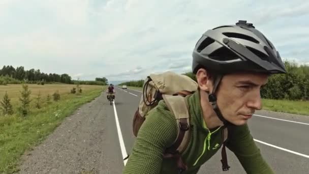 Escursionista ciclista va in bicicletta sulla strada sullo sfondo di alberi fuori città — Video Stock