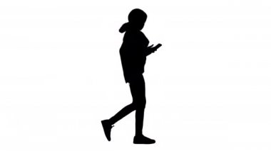 Gülümseyen kadın yürürken telefonuna mesaj yazıyor, Alpha Channel.