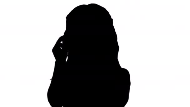 Silhouette Petite fille aux cheveux foncés en robe à pois portant des lunettes de soleil noires et renonçant à la caméra. — Video