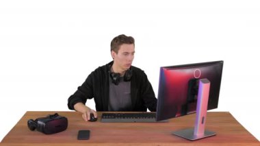 Gergin adam beyaz arka planda bilgisayar başında video oyunları izliyor..