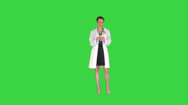 Paralı doktor. Kadın doktor para fırlatıyor ve yeşil ekranda poz veriyor, Chroma Key.. — Stok video