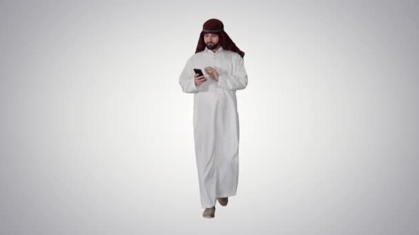 穿着keffiyeh的阿拉伯酋长在梯度背景下通过电话接收格栅新闻. — 图库视频影像