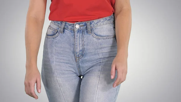 Casual woman walking in high jeans and red t-shirt on gradient b — Stock Photo, Image