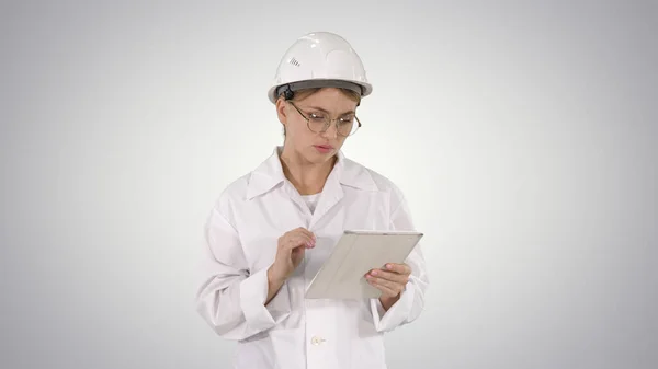 Pensive, thoughtful young engineer working with her tablet on gr — Stock Photo, Image