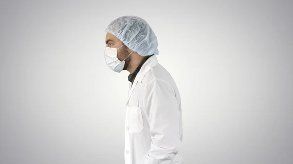 Bonito médico vestindo seu uniforme e usando uma máscara ele é wal — Fotografia de Stock