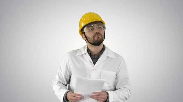 Site engineer cheching papers and something around him on gradie — Stock Photo, Image