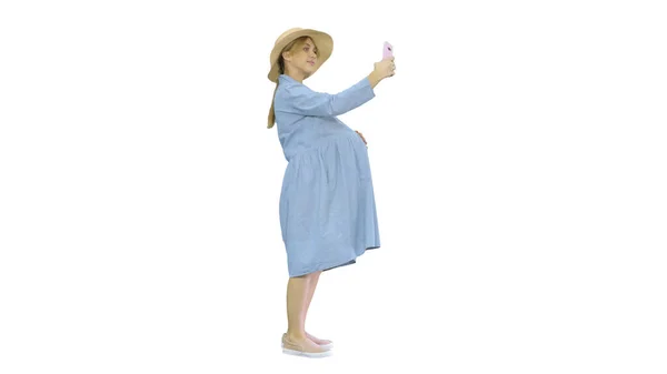 Lycklig gravid kvinna i hatt med hjälp av sin smartphone gör selfie — Stockfoto