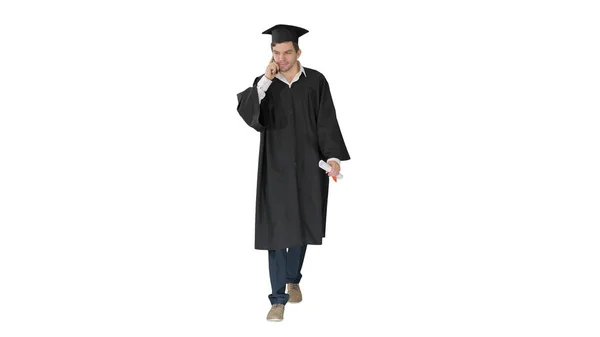 Male graduate in gown and mortarboard talking on the phone while — Stock Photo, Image