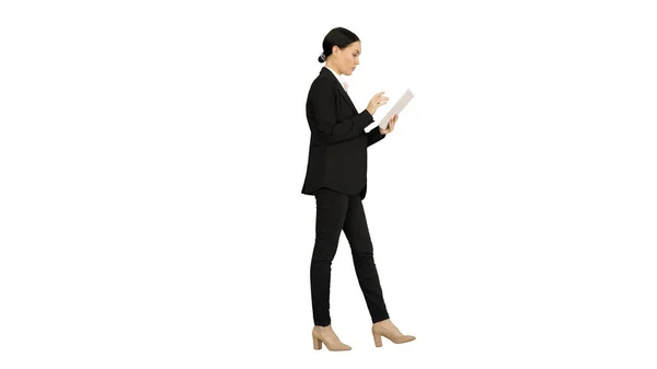 Бізнес-леді, використовуючи планшетну панель під час ходьби на білому фоні — стокове фото