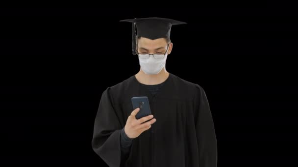 Jonge raduate student in medisch masker met behulp van telefoon lopen, Alpha Channel — Stockvideo