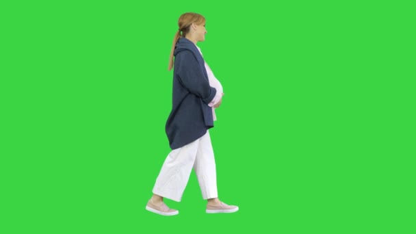 Szczęśliwa ciężarna blondynka spacerująca po zielonym ekranie, Chroma Key. — Wideo stockowe