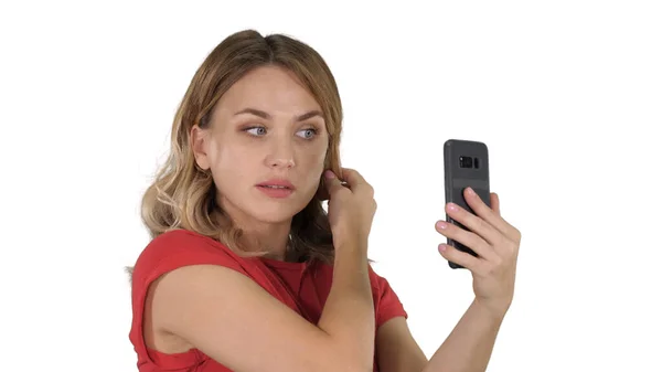 Bella donna preen utilizzando il suo telefono come uno specchio su bianco bac — Foto Stock