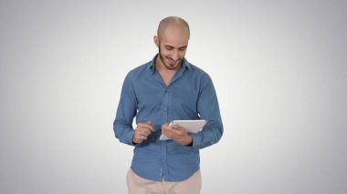 Gradyan üzerinde yürüyen ve tablet sörf interneti kullanan Arap adam