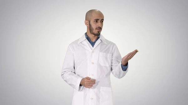 Arabo medico uomo in cappotto medico parlando e presentando con mano — Foto Stock