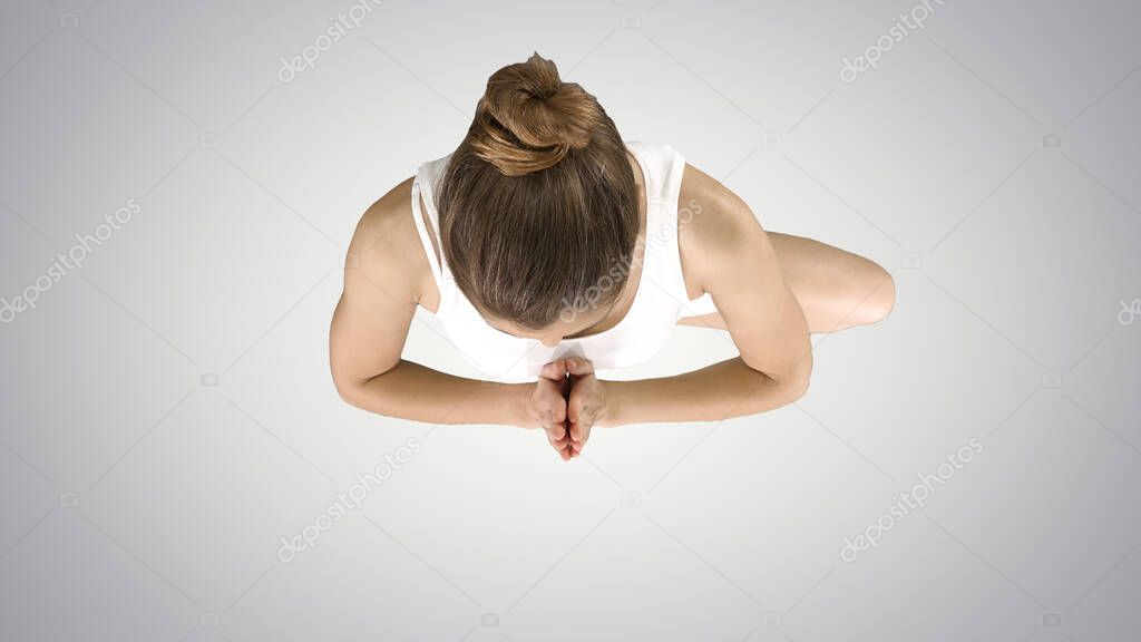 Tree pose, standing on one leg, hands in Namaste, prayer gesture