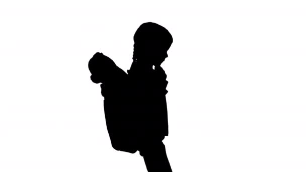 Silhouette Carina bambina che cammina a scuola con un orsacchiotto sporgente dal suo zaino. — Video Stock