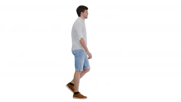 カジュアル若い男歩くと進む白の背景に. — ストック動画