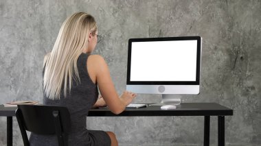 İş kadını yaratıcı ofiste masaüstü bilgisayarını kullanıyor. Beyaz D