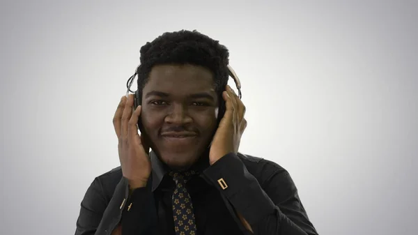 Hombre afroamericano sosteniendo auriculares con ambas manos y groo — Foto de Stock