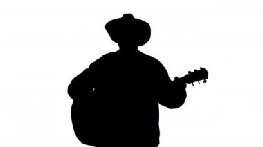 Ormanın silueti Akustik gitarlı adam şarkı söylüyor.