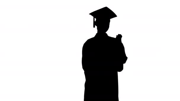 Силует Усміхнена студентка-жінка у випускному халаті позує з дипломом . — стокове відео