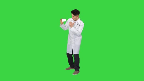 新しい薬を提示し、緑の画面上で踊る若い医師,クロマキー. — ストック動画