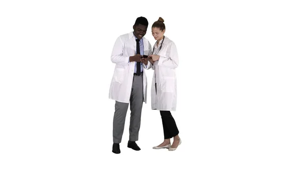 Equipe médica olhando para o telefone juntos no fundo branco. — Fotografia de Stock