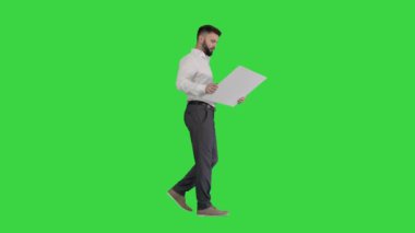 İşadamı yürüyor ve yeşil ekran, Chroma Key 'in planına bakıyor..