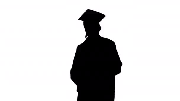 Sylwetka Szczęśliwy student w szlafroku ukończenia szkoły pozowanie z dyplomem i pokazano kciuki do góry. — Wideo stockowe