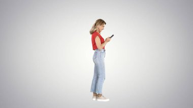 Değişken arkaplanda cep telefonuyla yazı yazan sıradan bir genç kadın.