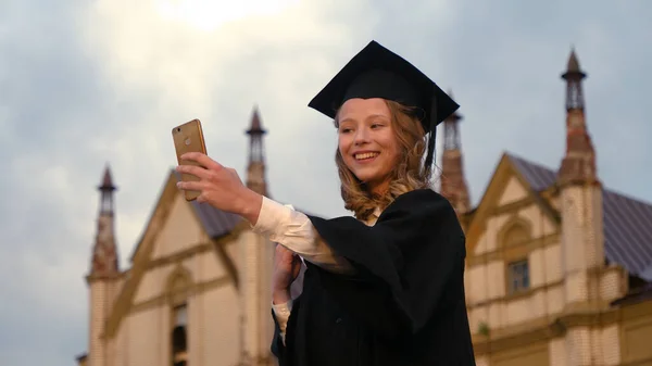 Mooi Aantrekkelijk Afgestudeerd vrouw in pet en toga glimlach en t — Stockfoto